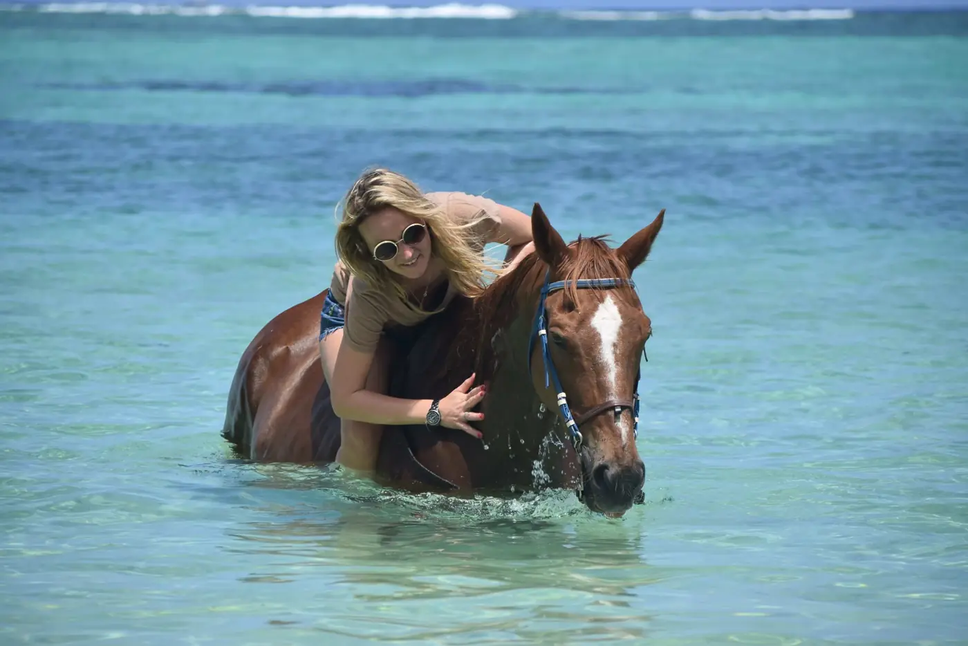 Horseback rider in shallow turquoise water